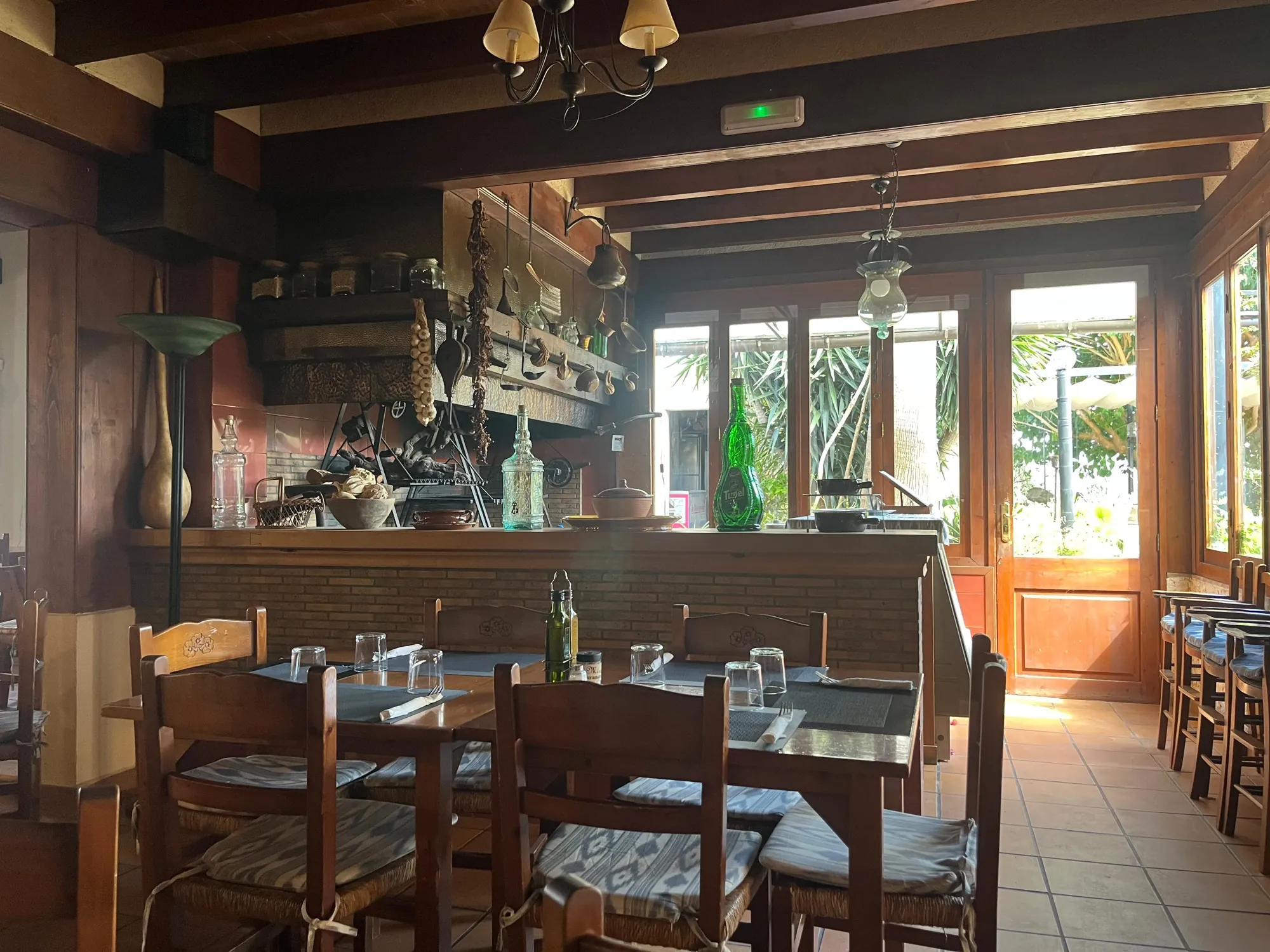 Comedor interior con barra de madera y mesas preparadas